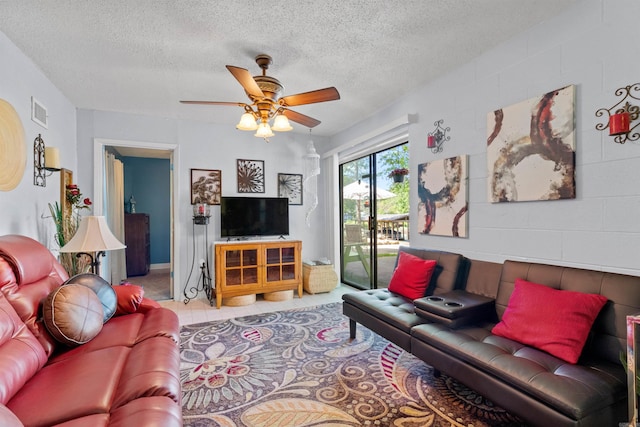 tiled living room featuring ceiling fan and a textured ceiling