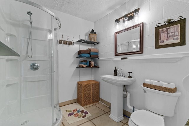 bathroom featuring sink, tile patterned floors, a textured ceiling, toilet, and walk in shower