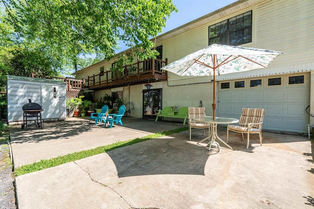 view of patio featuring a garage and an outbuilding