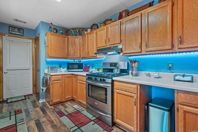 kitchen with dark hardwood / wood-style flooring, a textured ceiling, and gas stove