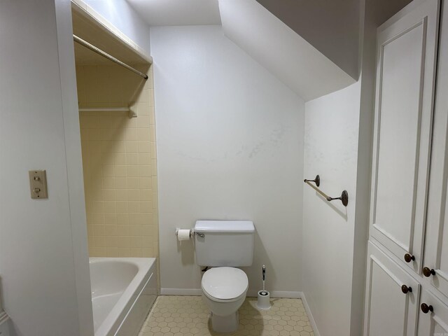 bathroom with tile patterned flooring, toilet, and tiled shower / bath combo