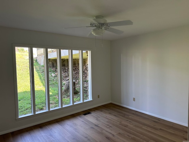 empty room with ceiling fan and hardwood / wood-style flooring