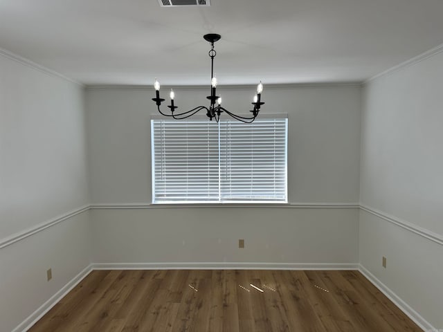 unfurnished dining area with hardwood / wood-style flooring, an inviting chandelier, and crown molding