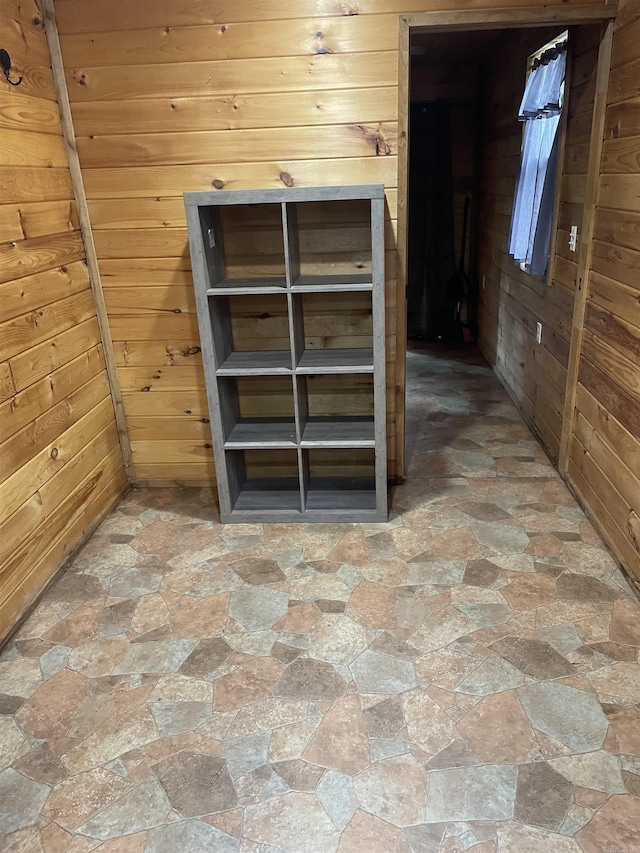 interior space featuring stone finish flooring and wooden walls