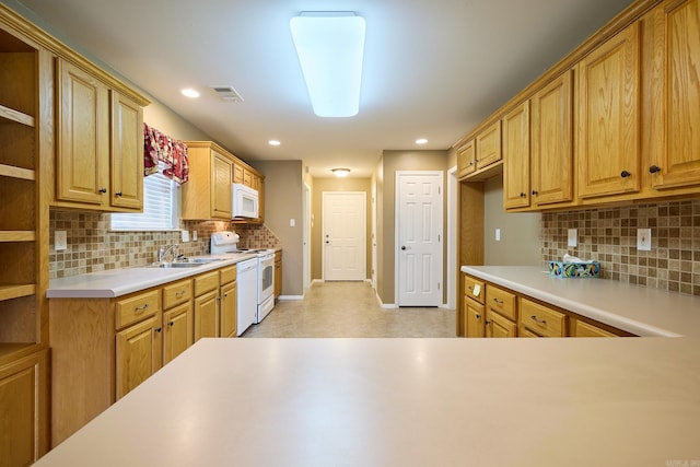 kitchen featuring decorative backsplash, white appliances, and sink