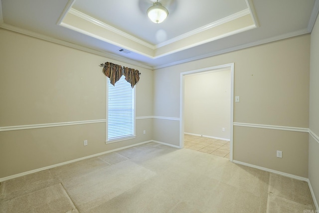 carpeted empty room with a tray ceiling, ceiling fan, and ornamental molding