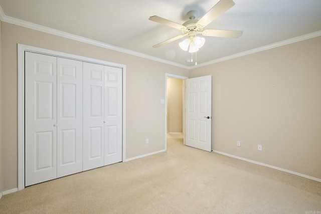 unfurnished bedroom featuring ceiling fan, a closet, light carpet, and ornamental molding