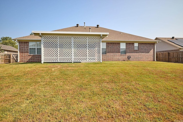 rear view of property with a yard