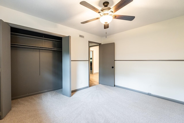 unfurnished bedroom with a closet, ceiling fan, and light colored carpet