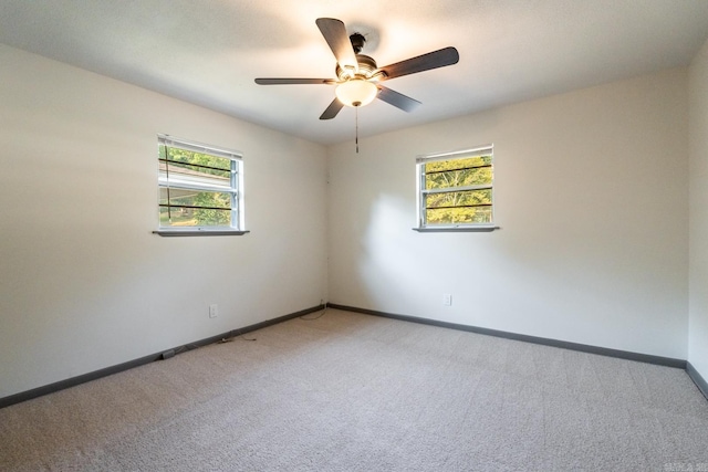 carpeted spare room with ceiling fan and a healthy amount of sunlight