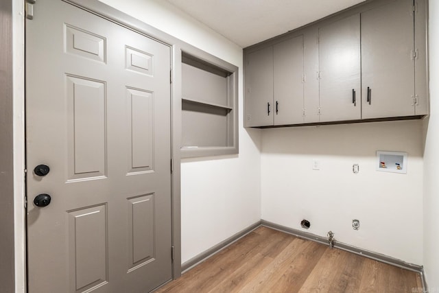 laundry room featuring light hardwood / wood-style floors, hookup for a washing machine, gas dryer hookup, and cabinets