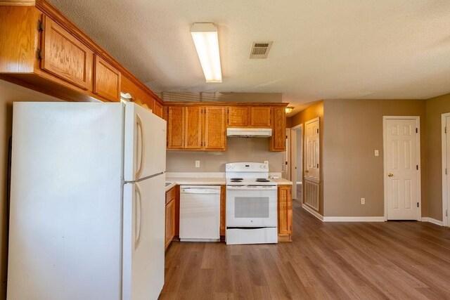 kitchen with white appliances and hardwood / wood-style flooring