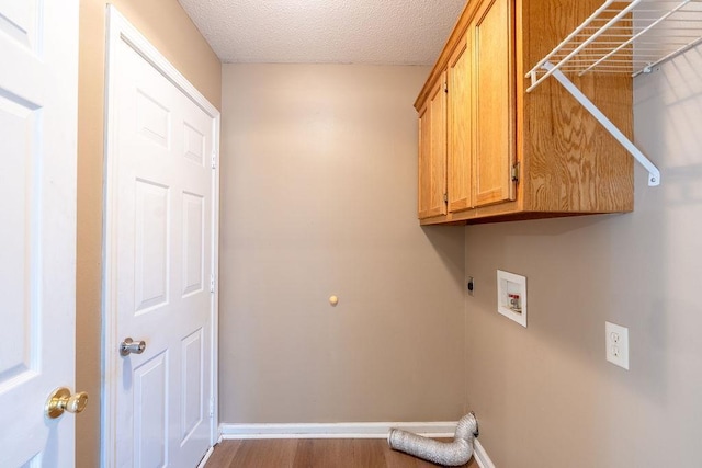 clothes washing area featuring washer hookup, hardwood / wood-style floors, a textured ceiling, cabinets, and hookup for an electric dryer