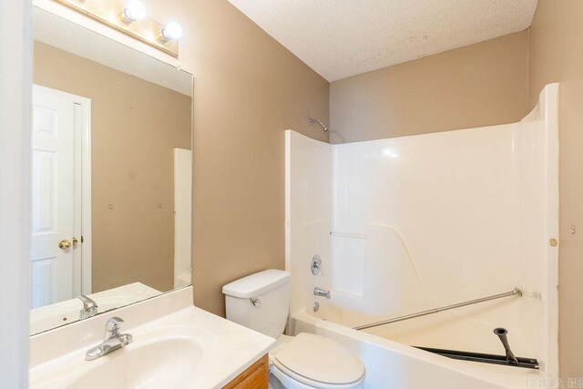 full bathroom with washtub / shower combination, toilet, a textured ceiling, and vanity