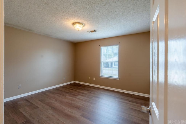 unfurnished room featuring hardwood / wood-style floors and a textured ceiling