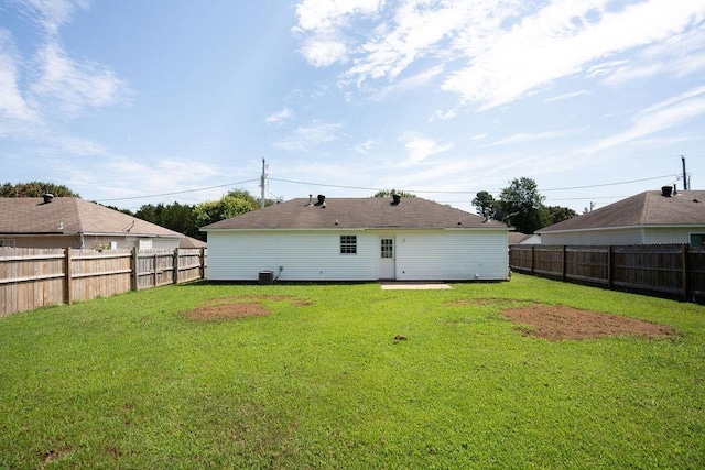 back of property featuring central air condition unit and a lawn