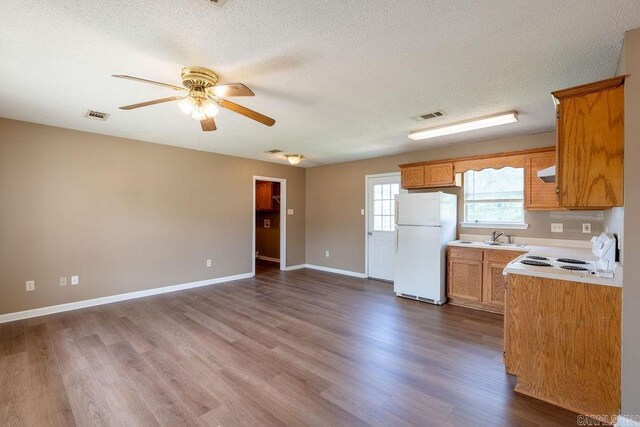 kitchen featuring sink, white refrigerator, dark hardwood / wood-style flooring, ceiling fan, and stove