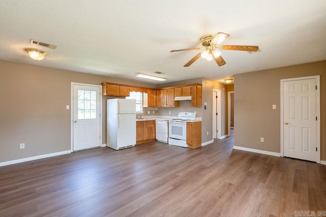 kitchen featuring white appliances, light wood-type flooring, a textured ceiling, ceiling fan, and sink