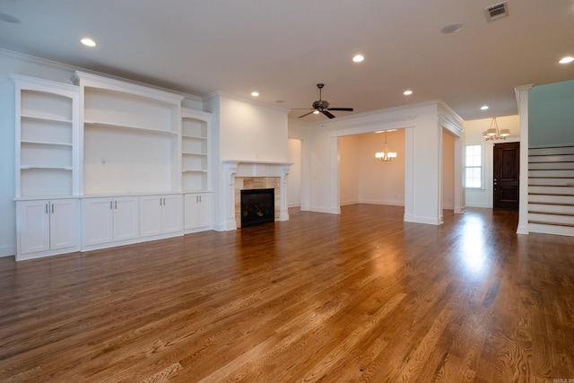 unfurnished living room featuring hardwood / wood-style floors, crown molding, and a tile fireplace