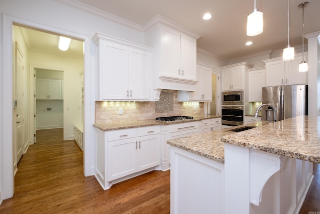 kitchen featuring appliances with stainless steel finishes, decorative light fixtures, hardwood / wood-style floors, and decorative backsplash