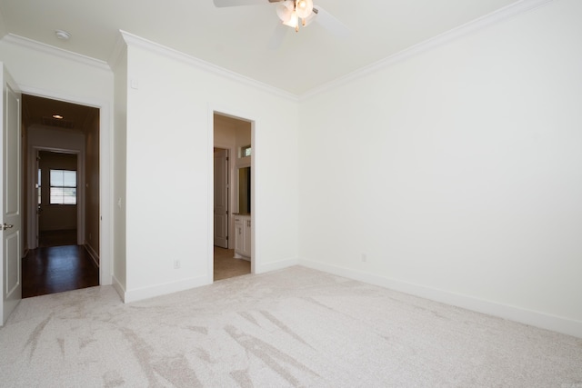 carpeted spare room with ceiling fan and ornamental molding