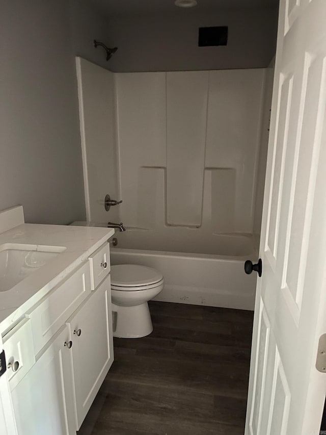 full bathroom with vanity, toilet, hardwood / wood-style floors, and tub / shower combination