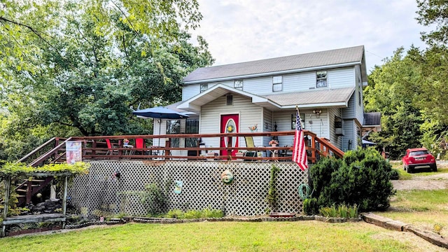 back of property with a yard and a wooden deck