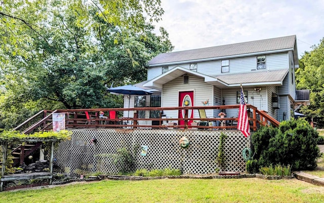 view of front of property with a wooden deck and a front lawn