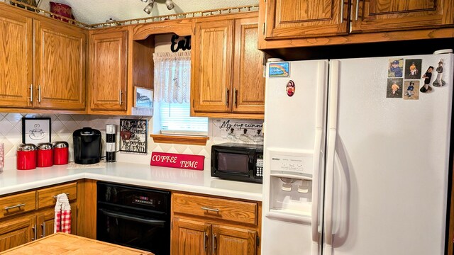 kitchen featuring backsplash, a textured ceiling, and black appliances