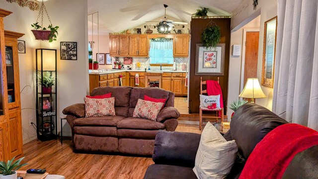 living room with light wood-type flooring, ceiling fan, and lofted ceiling