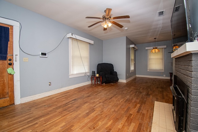 unfurnished living room featuring hardwood / wood-style flooring, a fireplace, and ceiling fan