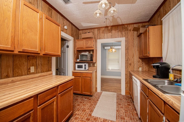 kitchen featuring wood walls, hanging light fixtures, ornamental molding, and white appliances