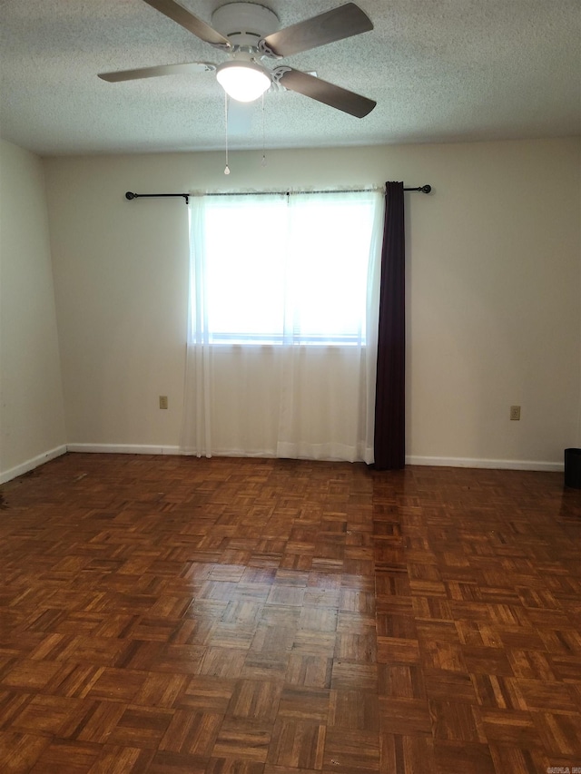 unfurnished room with ceiling fan, dark parquet floors, and a textured ceiling