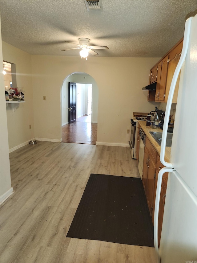 kitchen featuring a textured ceiling, light hardwood / wood-style flooring, ceiling fan, and white fridge