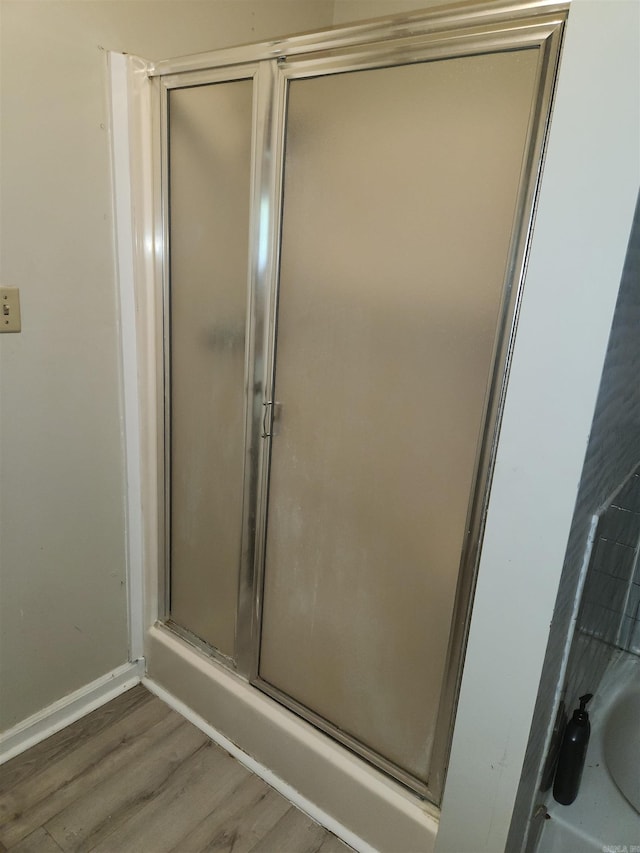 bathroom featuring hardwood / wood-style floors and a shower with door