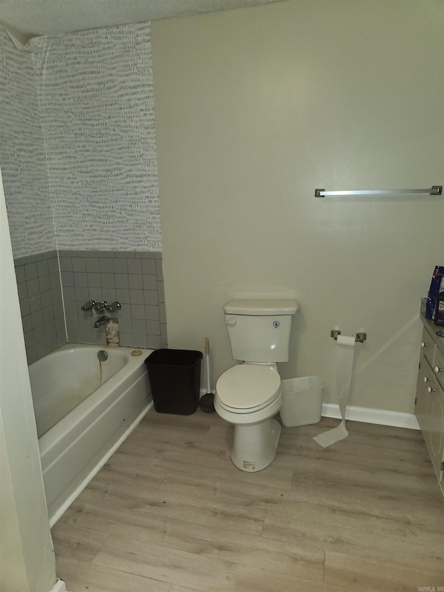 bathroom featuring wood-type flooring, a textured ceiling, vanity, and toilet