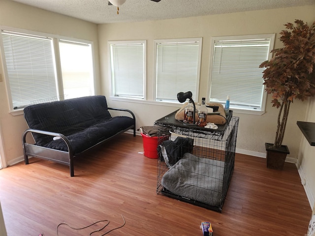 sitting room featuring ceiling fan, hardwood / wood-style flooring, and a textured ceiling