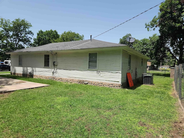 rear view of property with a lawn and central AC