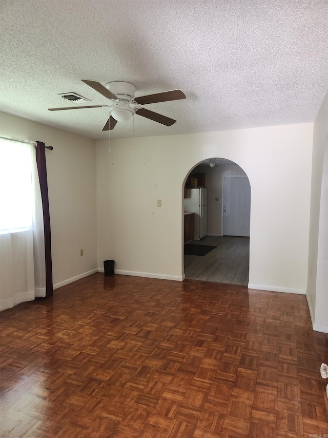 unfurnished room featuring ceiling fan, dark parquet floors, and a textured ceiling