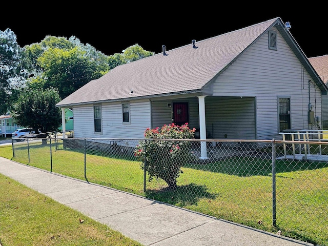 view of front of house with roof with shingles, a fenced front yard, and a front yard