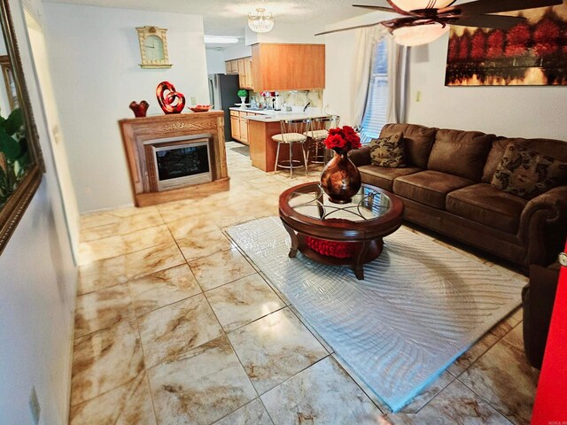 living room with ceiling fan and light tile patterned flooring