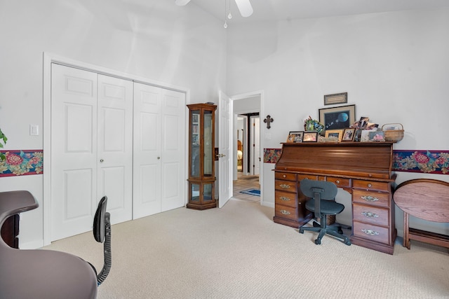carpeted office space featuring ceiling fan and high vaulted ceiling