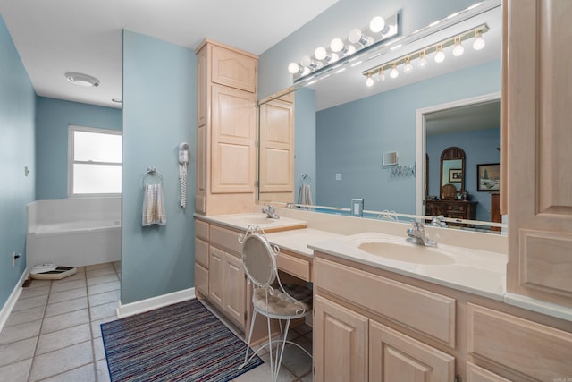 bathroom with tile patterned flooring, double vanity, a sink, baseboards, and a garden tub