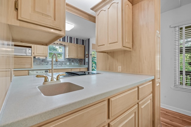 kitchen featuring a sink, light brown cabinets, light countertops, wood finished floors, and white appliances