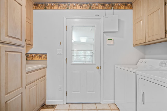 washroom featuring light tile patterned floors, cabinet space, baseboards, visible vents, and washer and clothes dryer