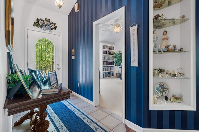 tiled entrance foyer with wallpapered walls and baseboards