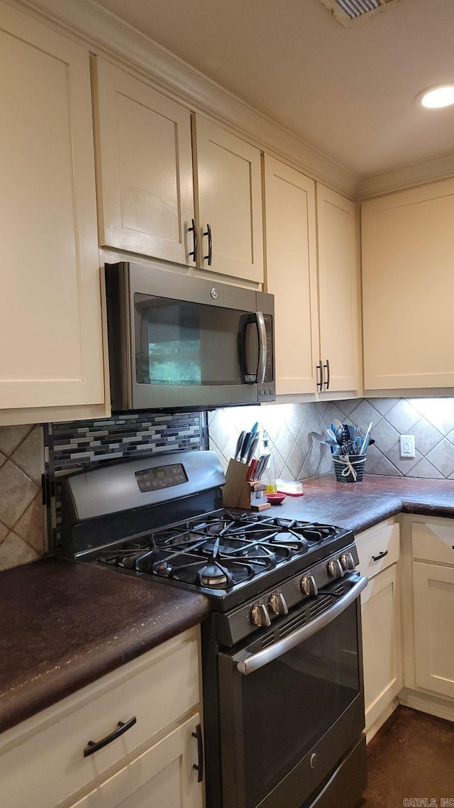 kitchen with stainless steel appliances, backsplash, and white cabinetry