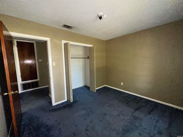 unfurnished bedroom with a textured ceiling, carpet floors, and a closet