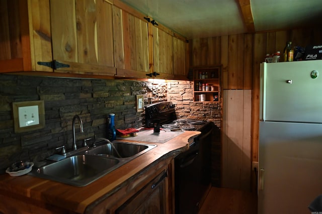 kitchen with sink, stainless steel refrigerator, black electric range oven, and backsplash