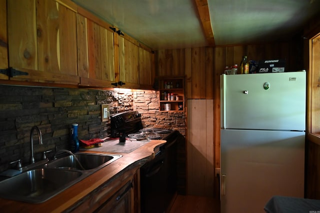 kitchen with sink, decorative backsplash, black range with electric stovetop, and fridge